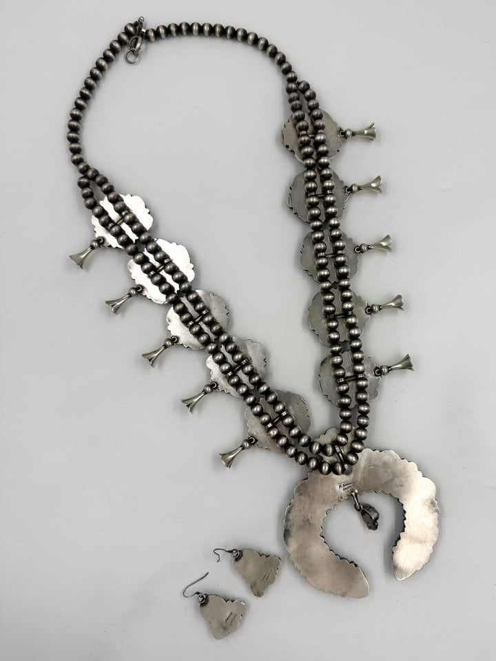 Silver back of sky blue and lavender colored turquoise squash blossom necklace 