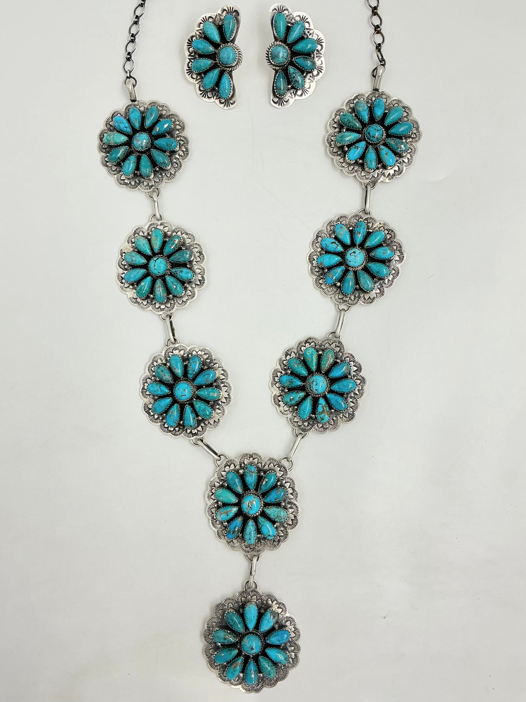 Y Shaped necklace and earrings set with turquoise floral designs on a white background