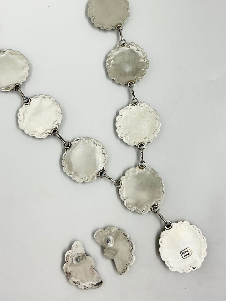 Silver back of Y shaped Turquoise and silver necklace showing stamped silver on a light gray background 
