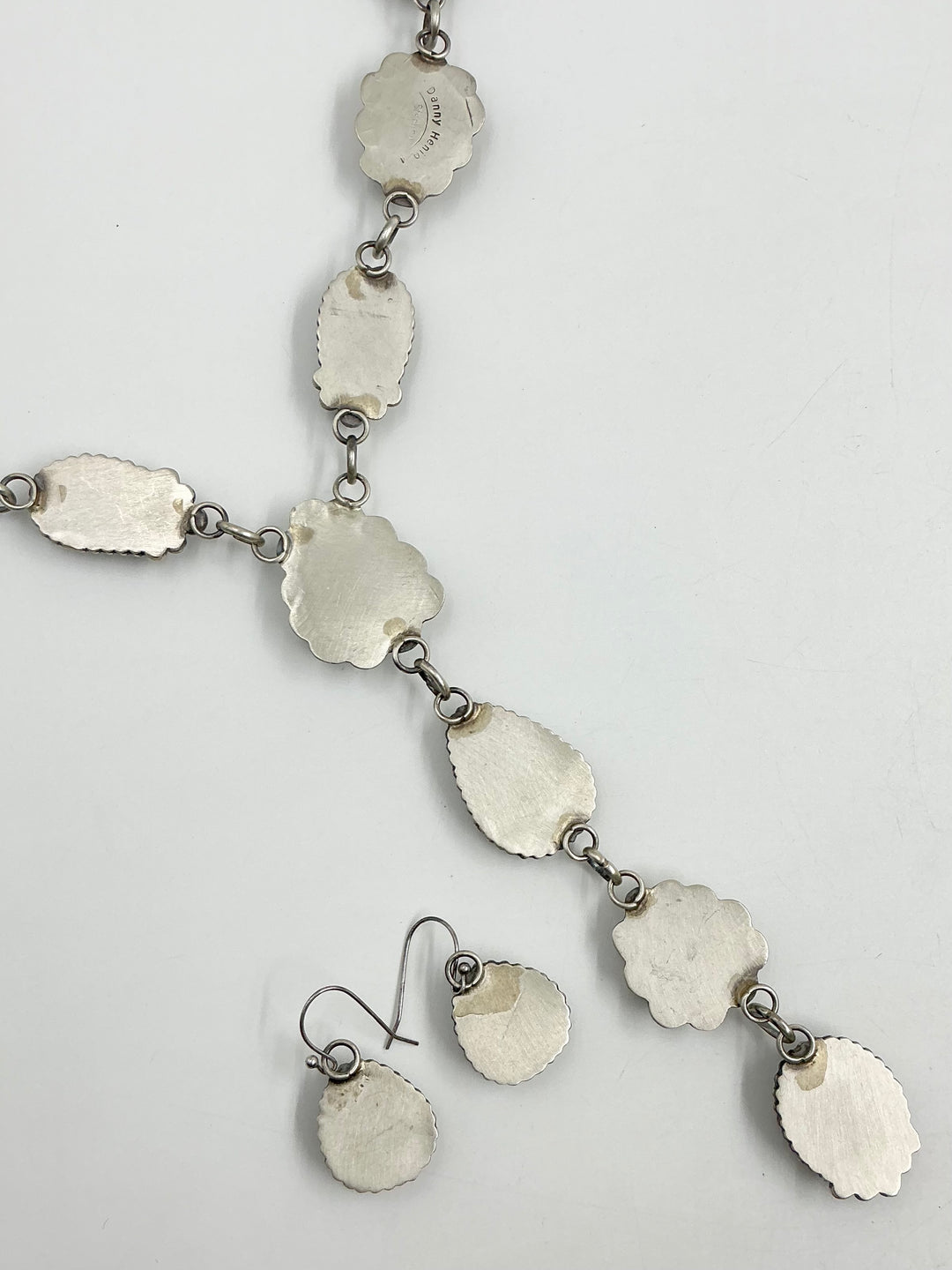 Silver back pf Y shaped Necklace with turquoise gemstones set in sterling silver with accents on a white background showing stamped silver. 