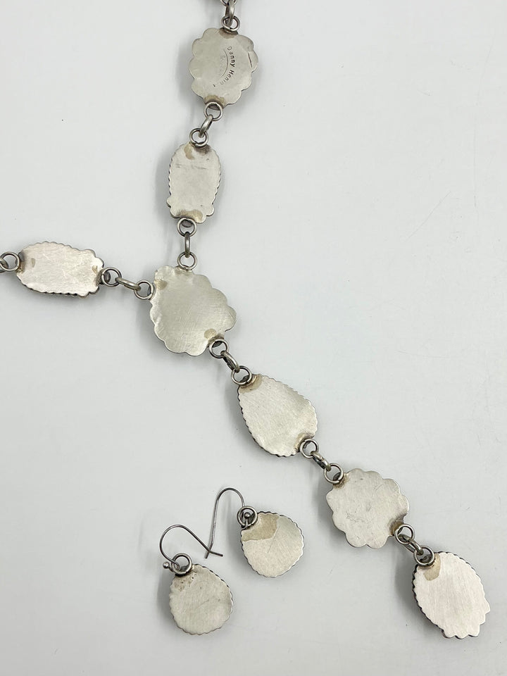 Silver back pf Y shaped Necklace with turquoise gemstones set in sterling silver with accents on a white background showing stamped silver. 