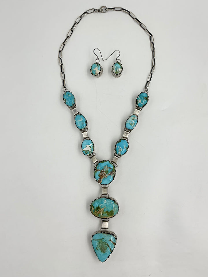Y shaped Necklace with blue, green and gold gemstones set in sterling silver with accents on a white background