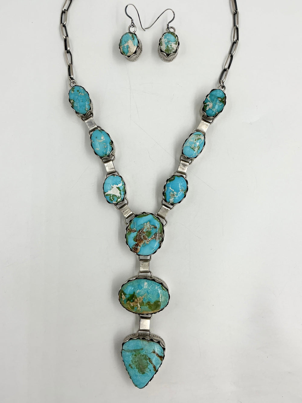 Y shaped Necklace with blue, green and gold gemstones set in sterling silver with accents on a white background
