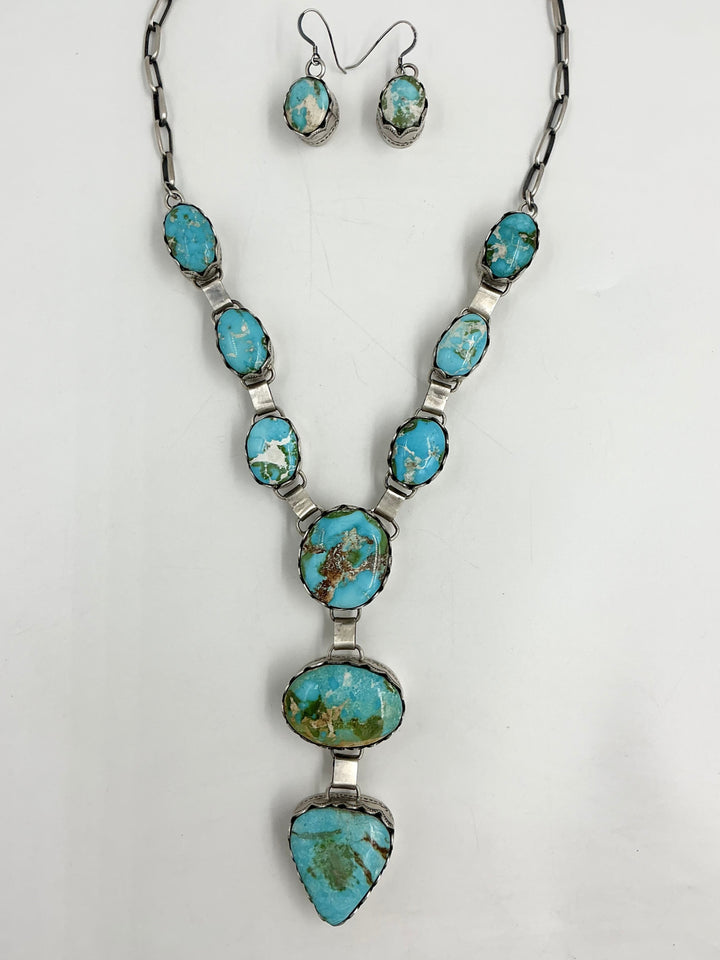 Y shaped Necklace with blue, green and gold gemstones set in sterling silver with accents on a white background