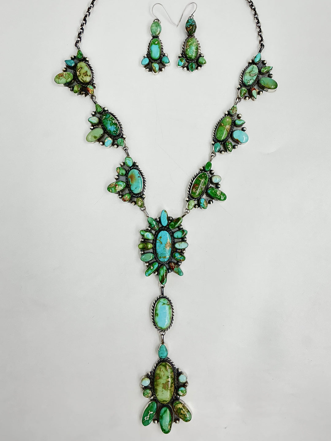 Y shaped necklace and earrings set with green and turquoise stone clusters set on sterling silver on a white background