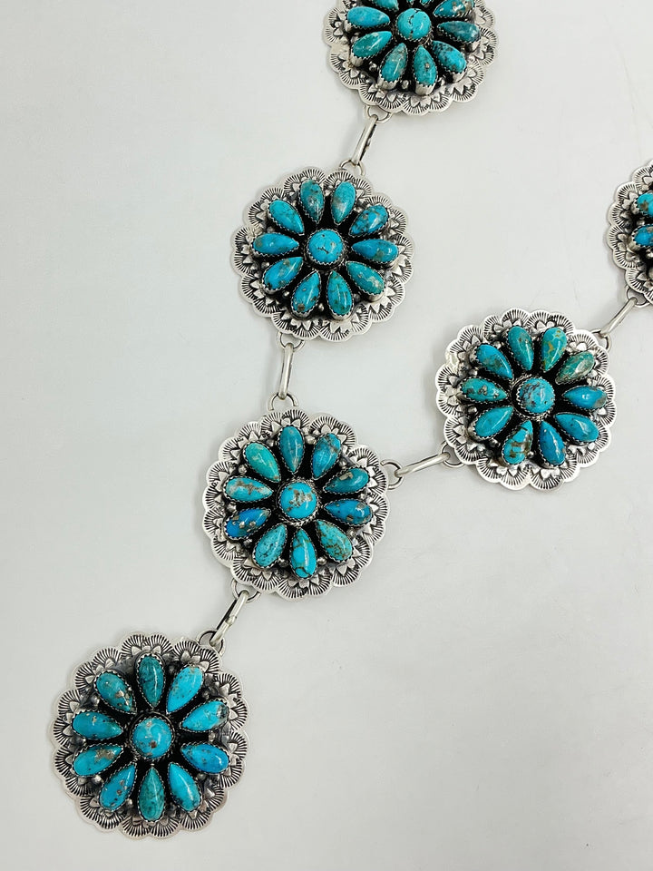 Y shaped Turquoise and silver necklace on a light gray background