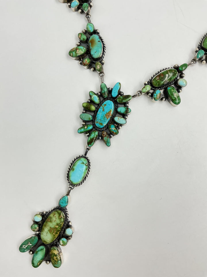Y shaped necklace and earrings set with green and turquoise stone clusters set on sterling silver on a white background