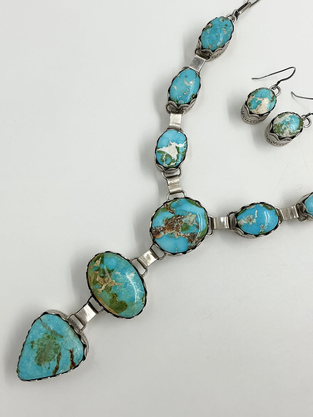 Y shaped Necklace with blue, green and gold gemstones set in sterling silver with accents on a white background