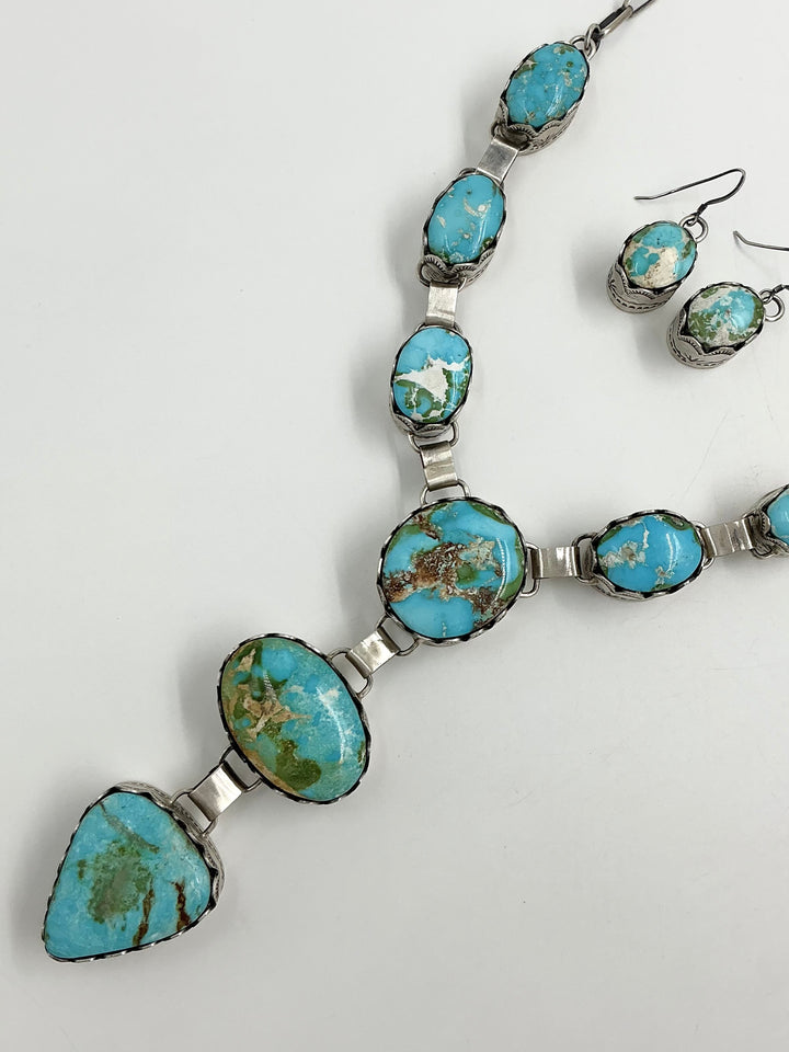 Y shaped Necklace with blue, green and gold gemstones set in sterling silver with accents on a white background