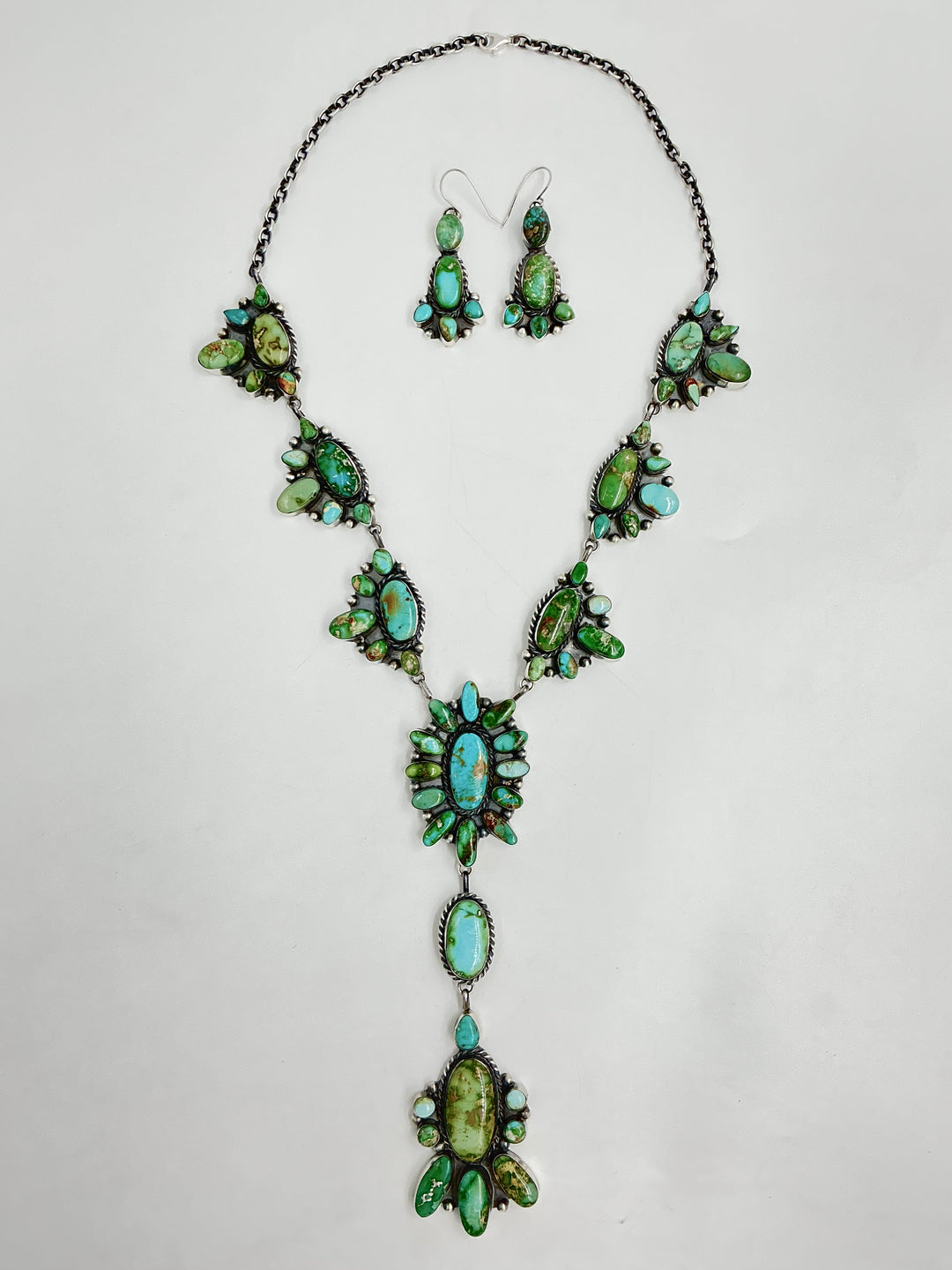 Y shaped necklace and earrings set with green and turquoise stone clusters set on sterling silver on a white background