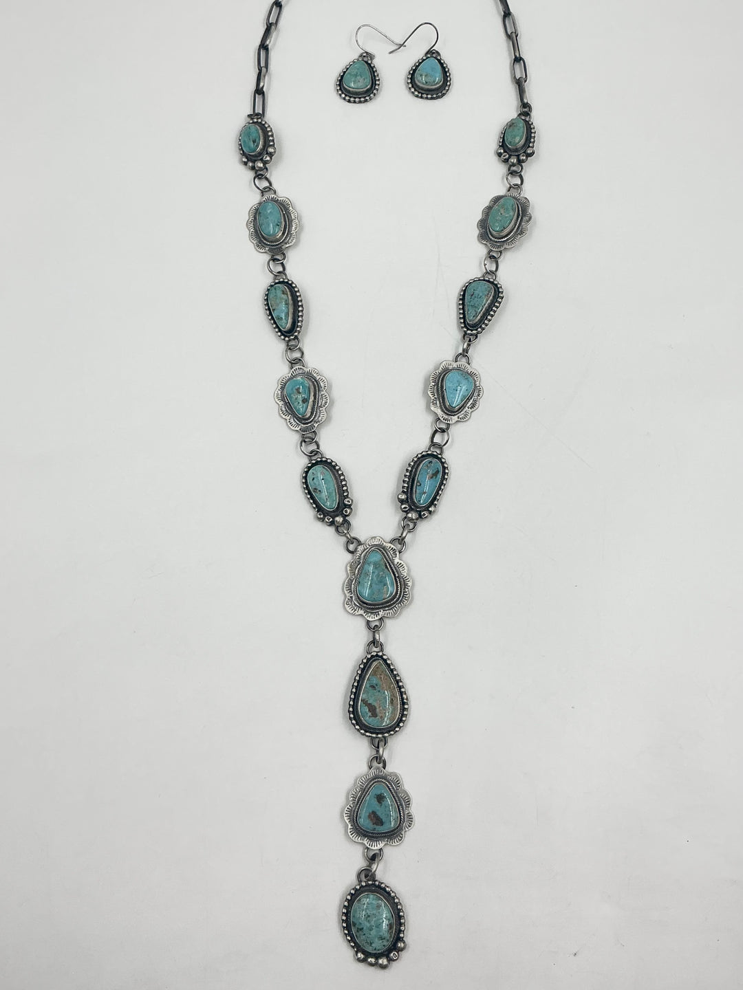  Y shaped Necklace turquoise stones set in sterling silver with accents on a white background with earrings. 