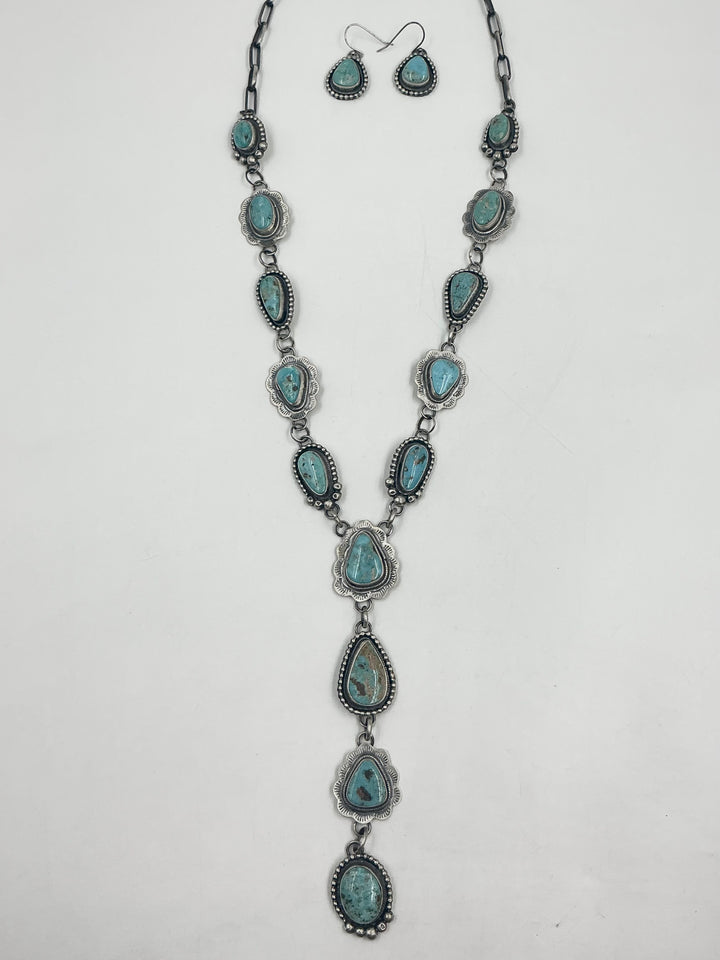  Y shaped Necklace turquoise stones set in sterling silver with accents on a white background with earrings. 