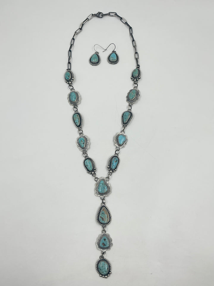  Y shaped Necklace turquoise stones set in sterling silver with accents on a white background with earrings. 