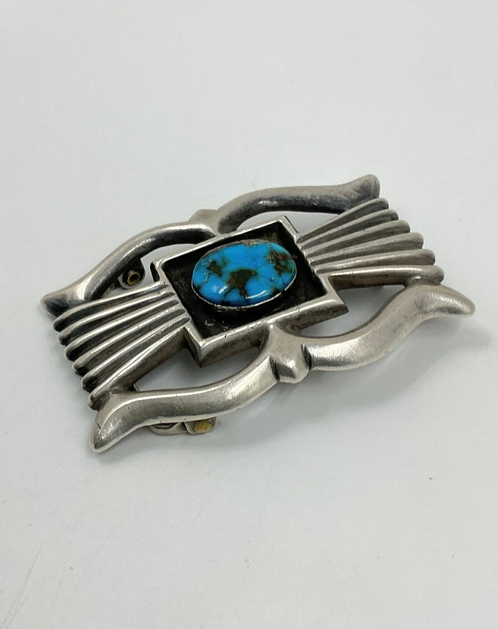 Silver belt buckle with a blue stone on a white background