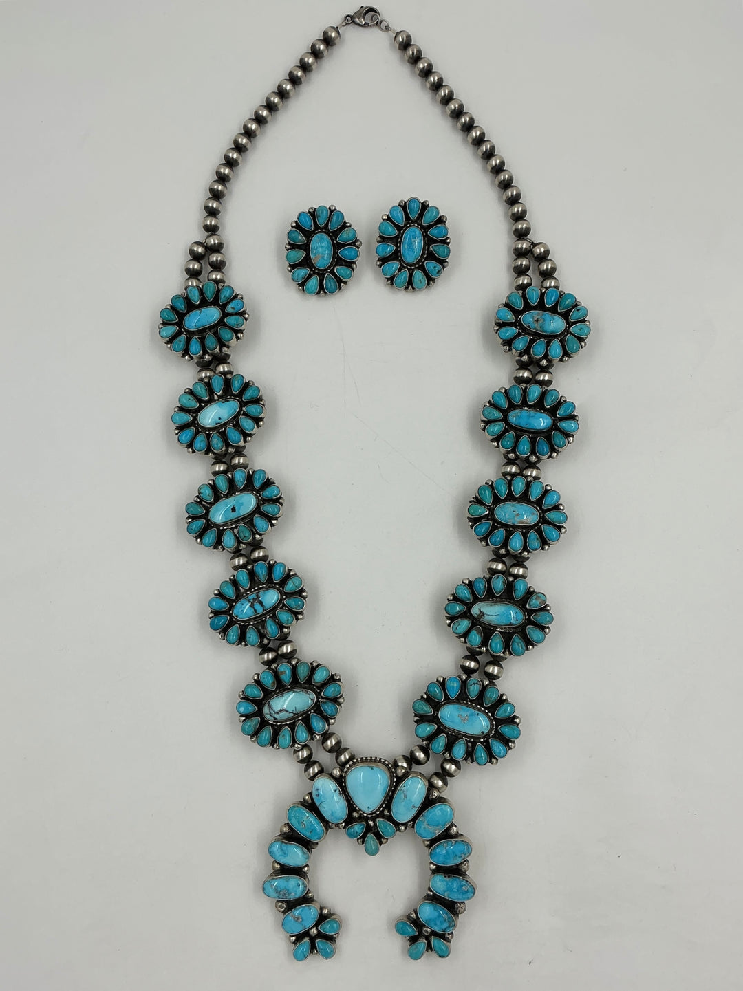 Turquoise stone necklace and earrings on a white background
