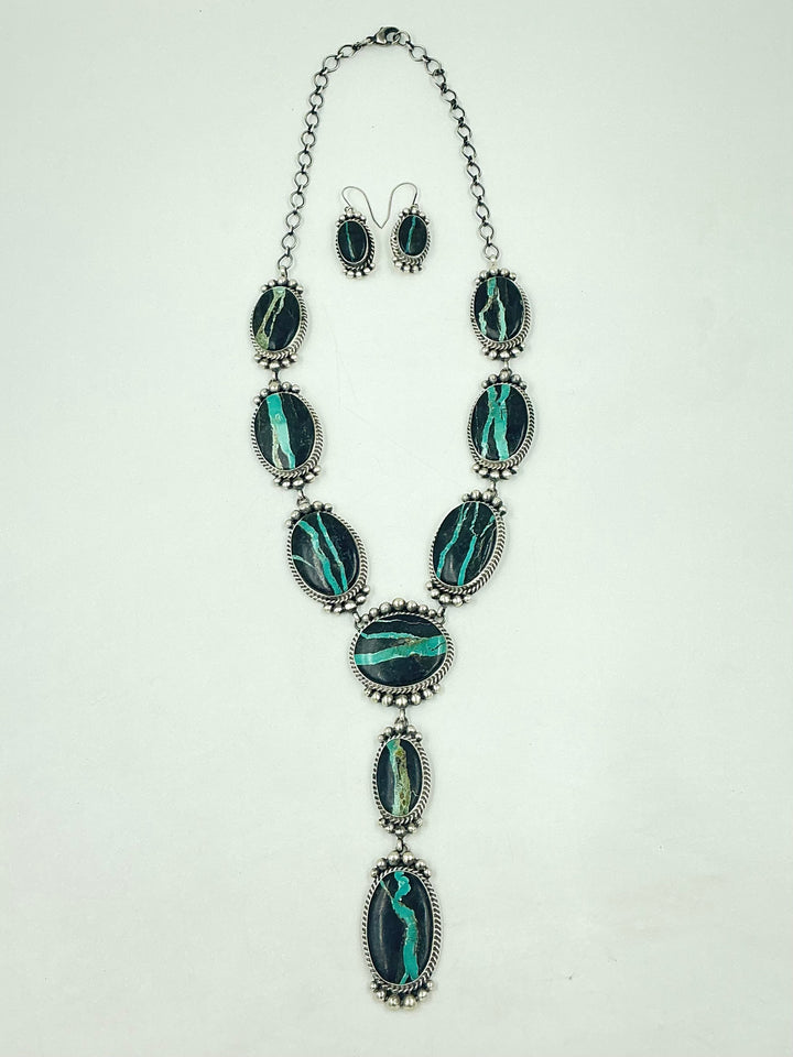 Y shaped Necklace with black and green gemstones set in sterling silver with accents on a white background