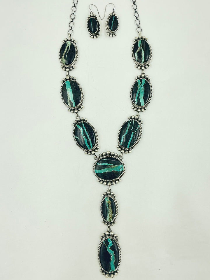 Y shaped Necklace with black and green gemstones set in sterling silver with accents on a white background