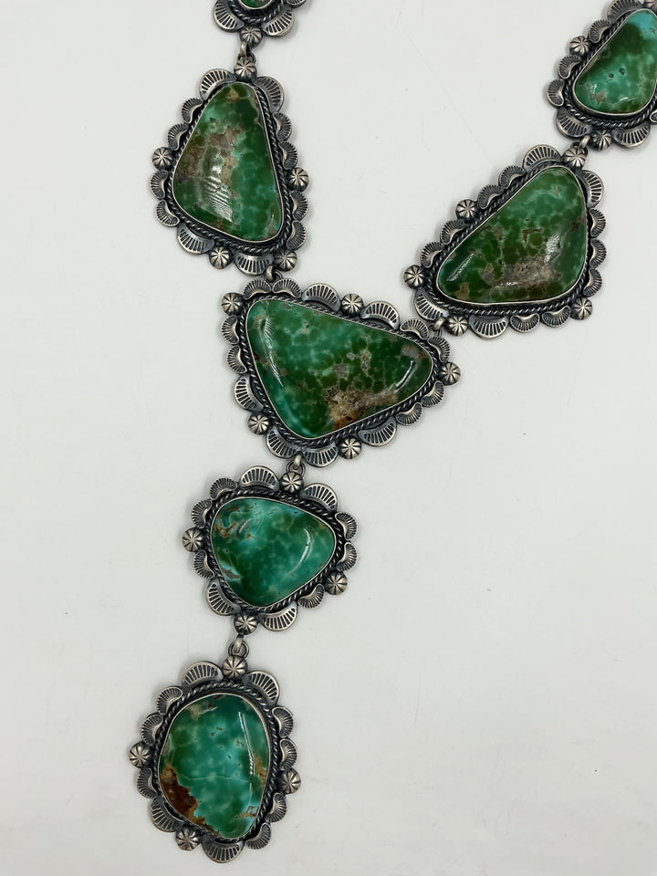 Y shaped Necklace with green gemstones and set in sterling silver with accents on a white background