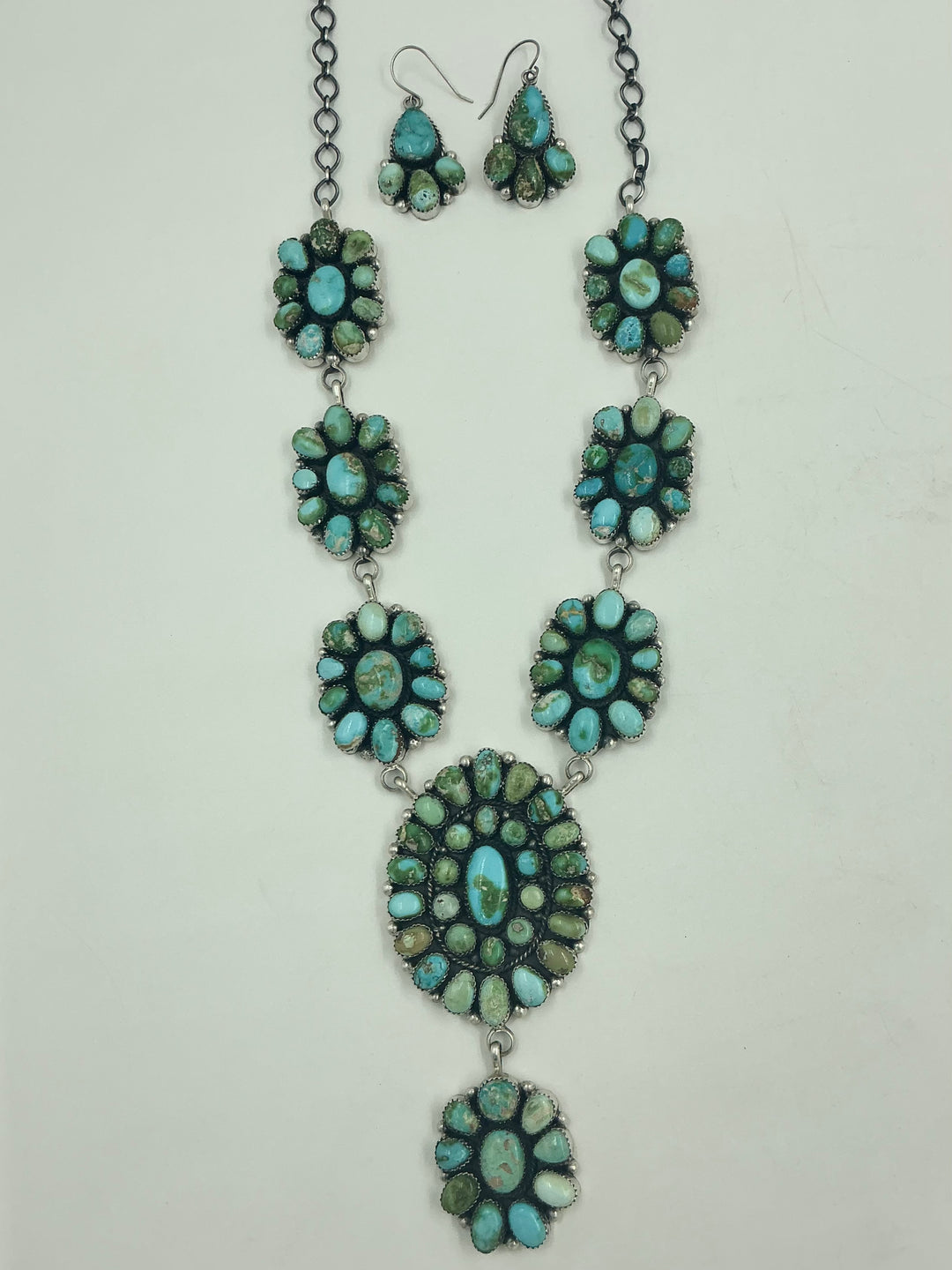 Y shaped Necklace with small green and blue gemstone clusters and set in round flower like sterling silver on a white background