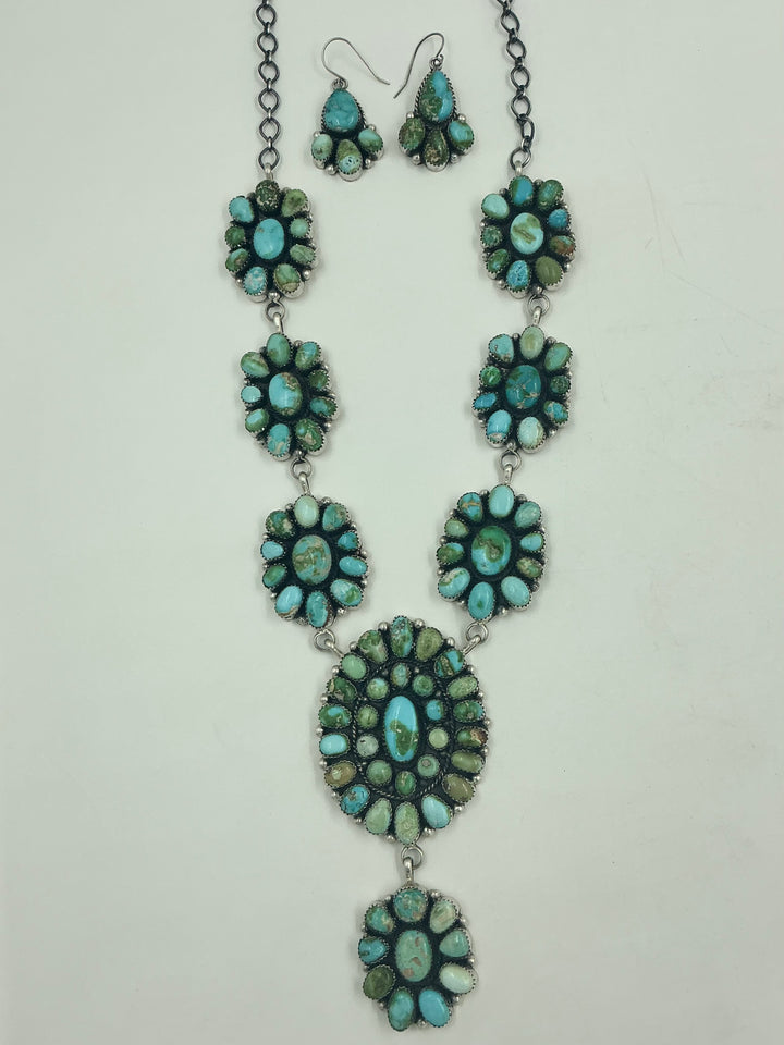 Y shaped Necklace with small green and blue gemstone clusters and set in round flower like sterling silver on a white background