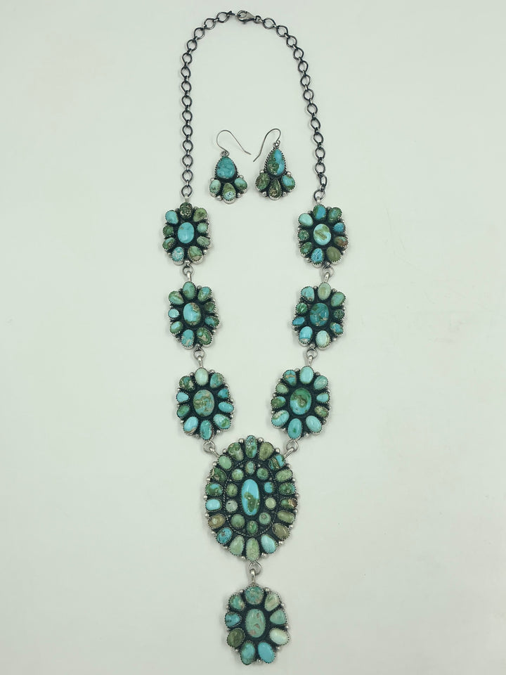 Y shaped Necklace with small green and blue gemstone clusters and set in round flower like sterling silver on a white background