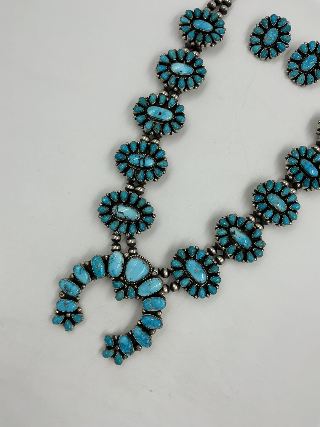 Turquoise stone necklace and earrings on a white background